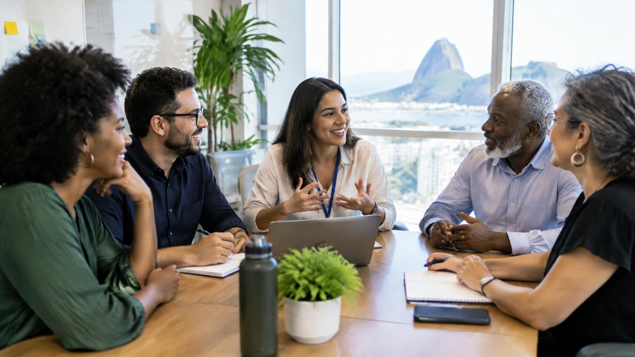 Group of diverse Brazilian professionals talking in a bright meeting room